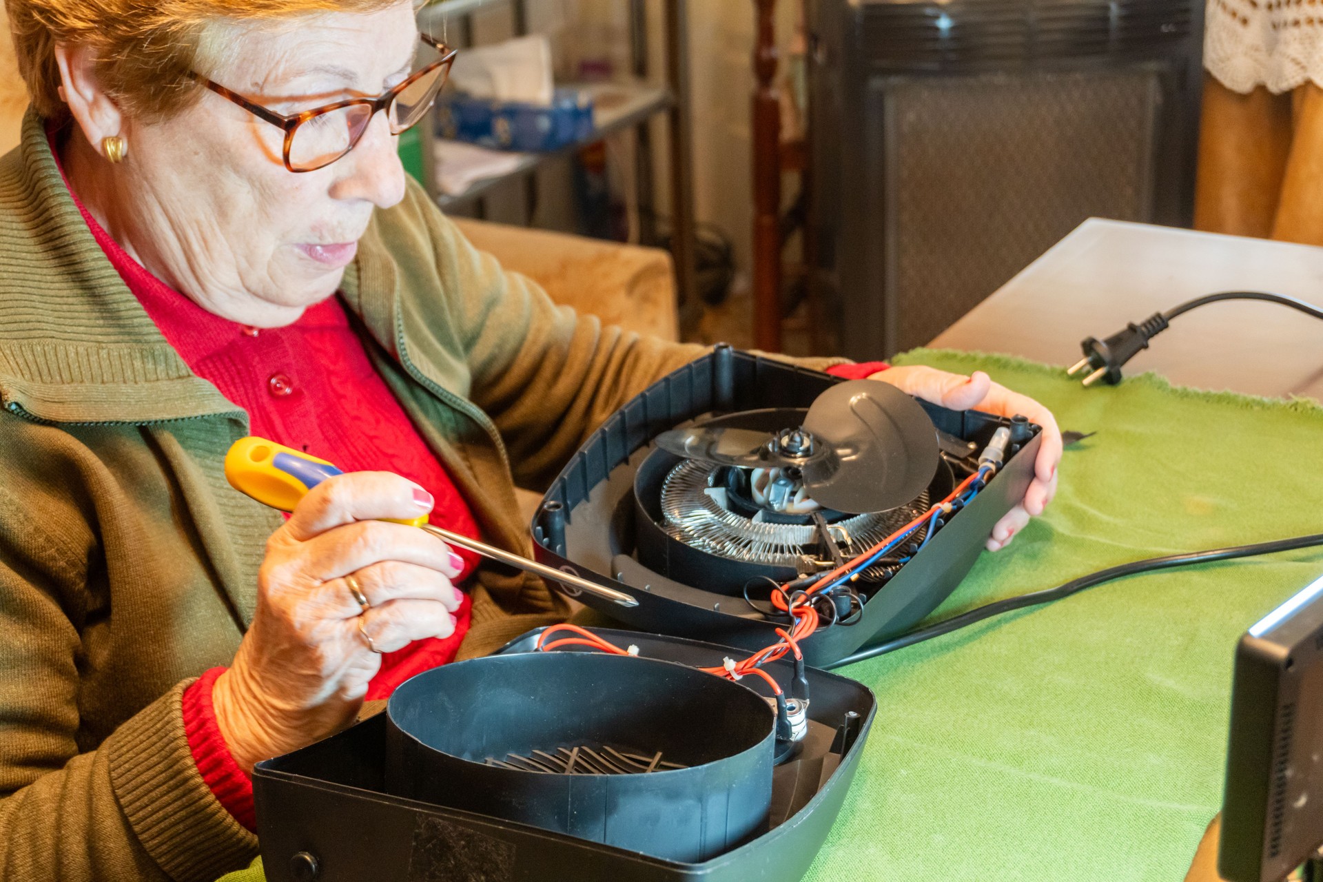 Senior handywoman  fixing  appliance at home